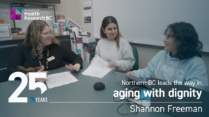 Image shows Dr. Shannon Freeman and two other researchers/students are sitting and discussing at a table. The image also features Michael Smith Health Research BC logo