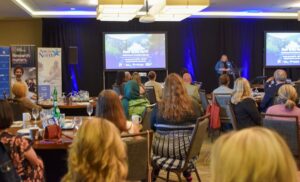 Wide shot of the audience listening to Davina Banner speaking onstage at the Made in the North event.